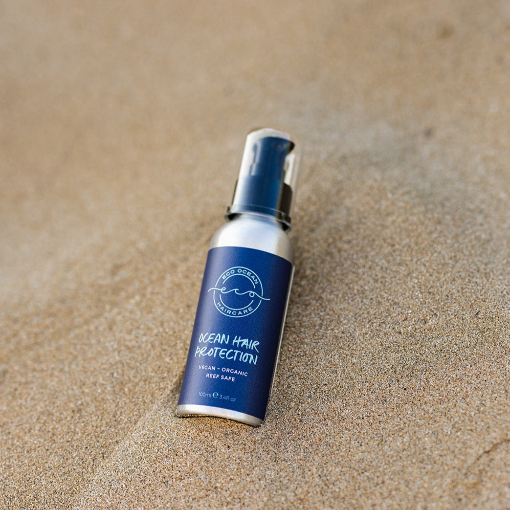 Aluminium bottle of Ocean Hair Protection on the beach.