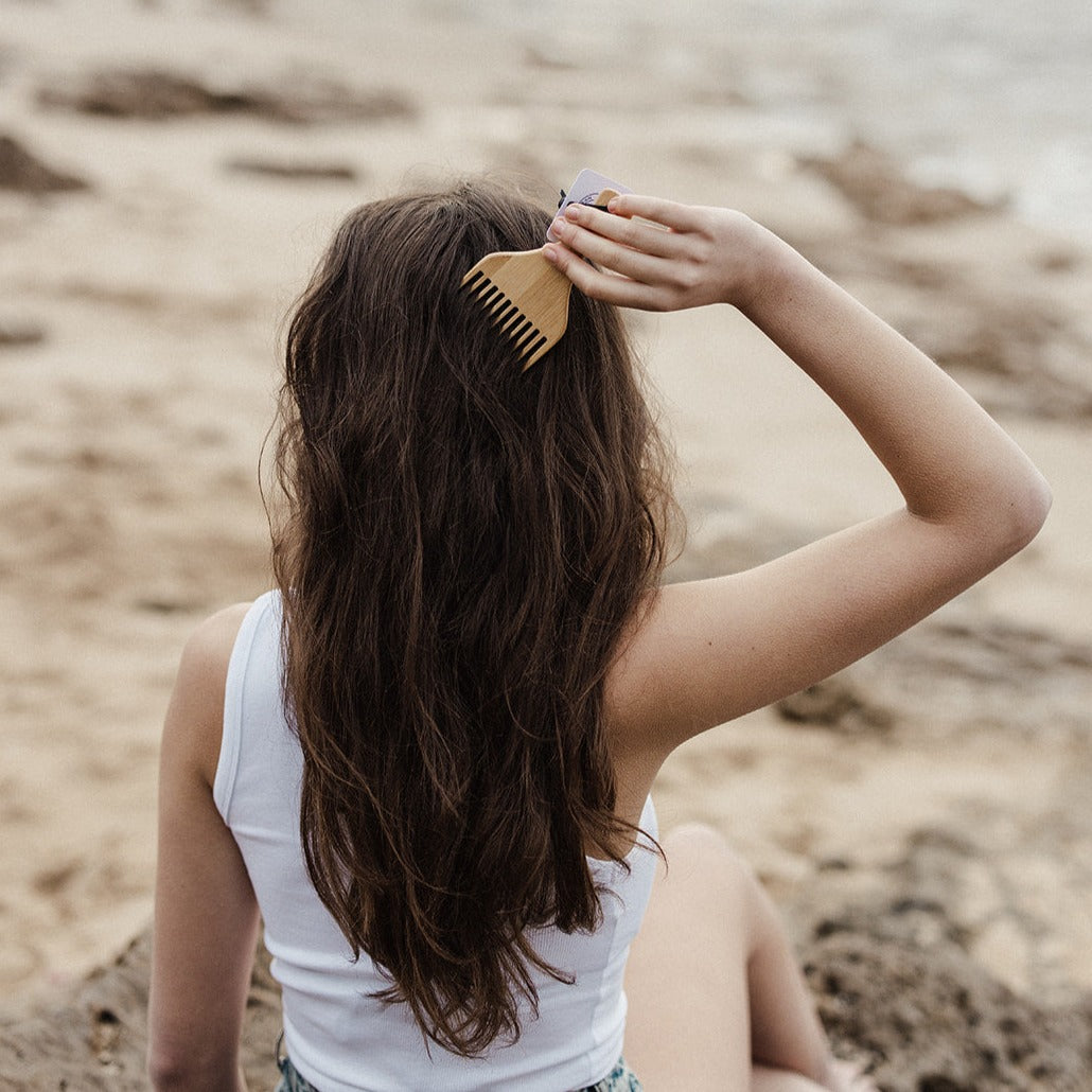 Woman combing her hair with Eco Ocean Haircare Bamboo Comb