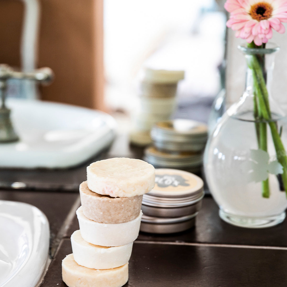 Plastic-free Enrich shampoo bars on bathroom sink. Eco Ocean haircare.