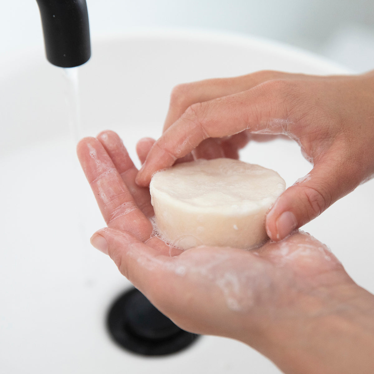 woman lathering hands with plastic-free 2-in-1 shampoo bar